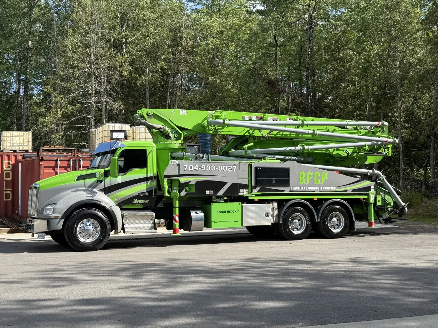 Black Flag’s green Putzmeister concrete pump on a Kenworth truck, with its boom folded for transport